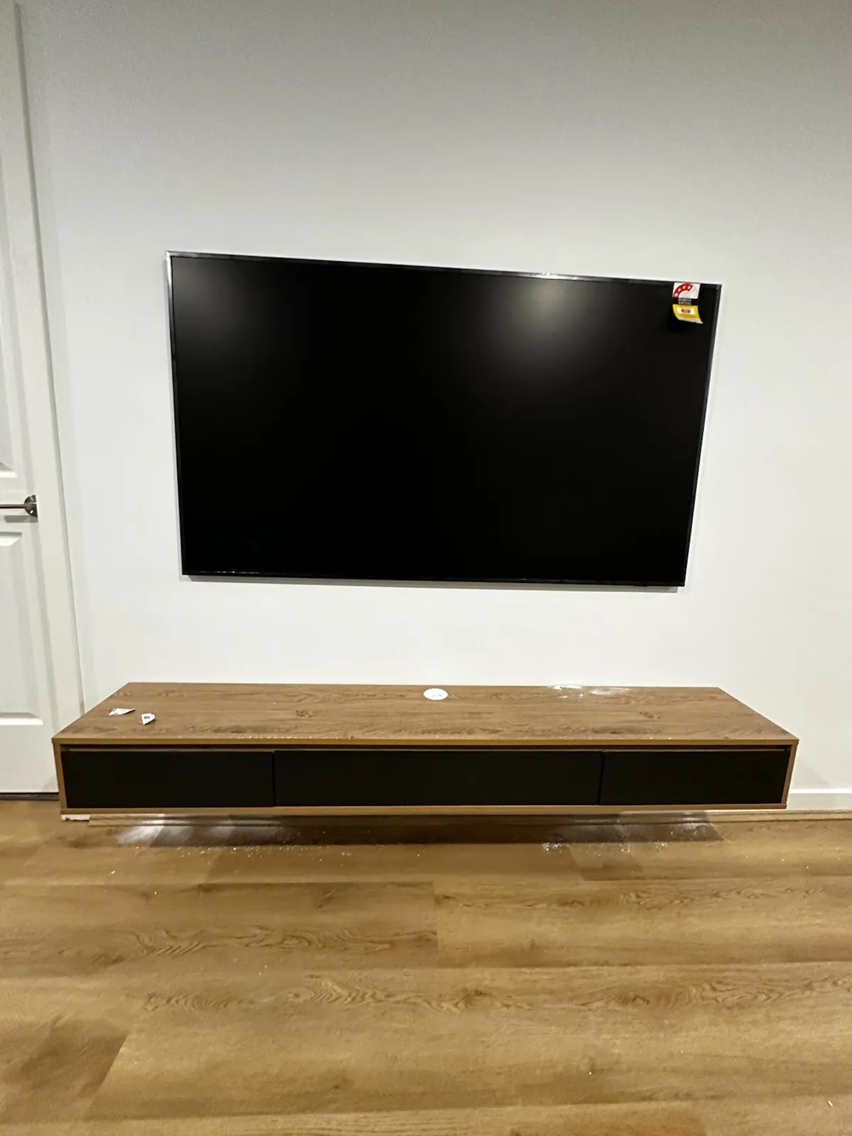 Large TV and soundbar installation above timber cabinet